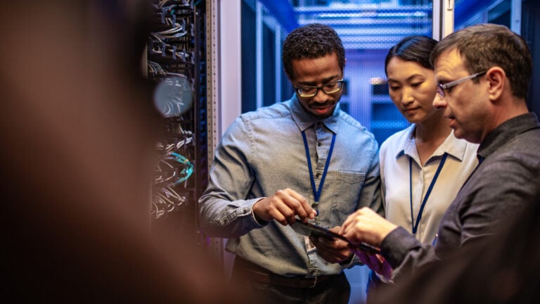 Software engineers working in IT companies, resolving problems in a company's server room.