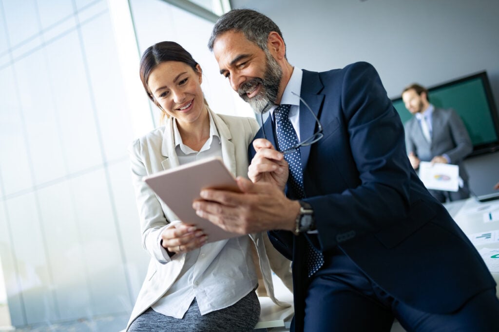 Business owners using a tablet device to look for top IT companies in Jacksonville, FL.