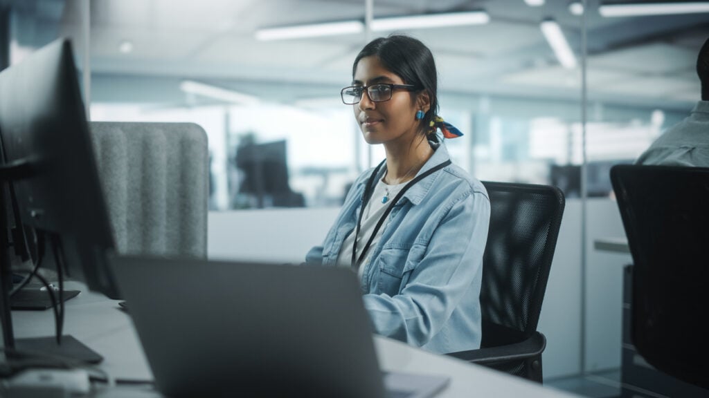 Female virtual CIO using a computer while working on a business's IT tasks.