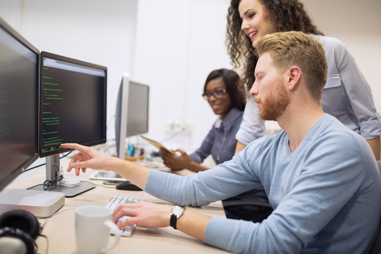 Group of IT professionals working on computers in an office.