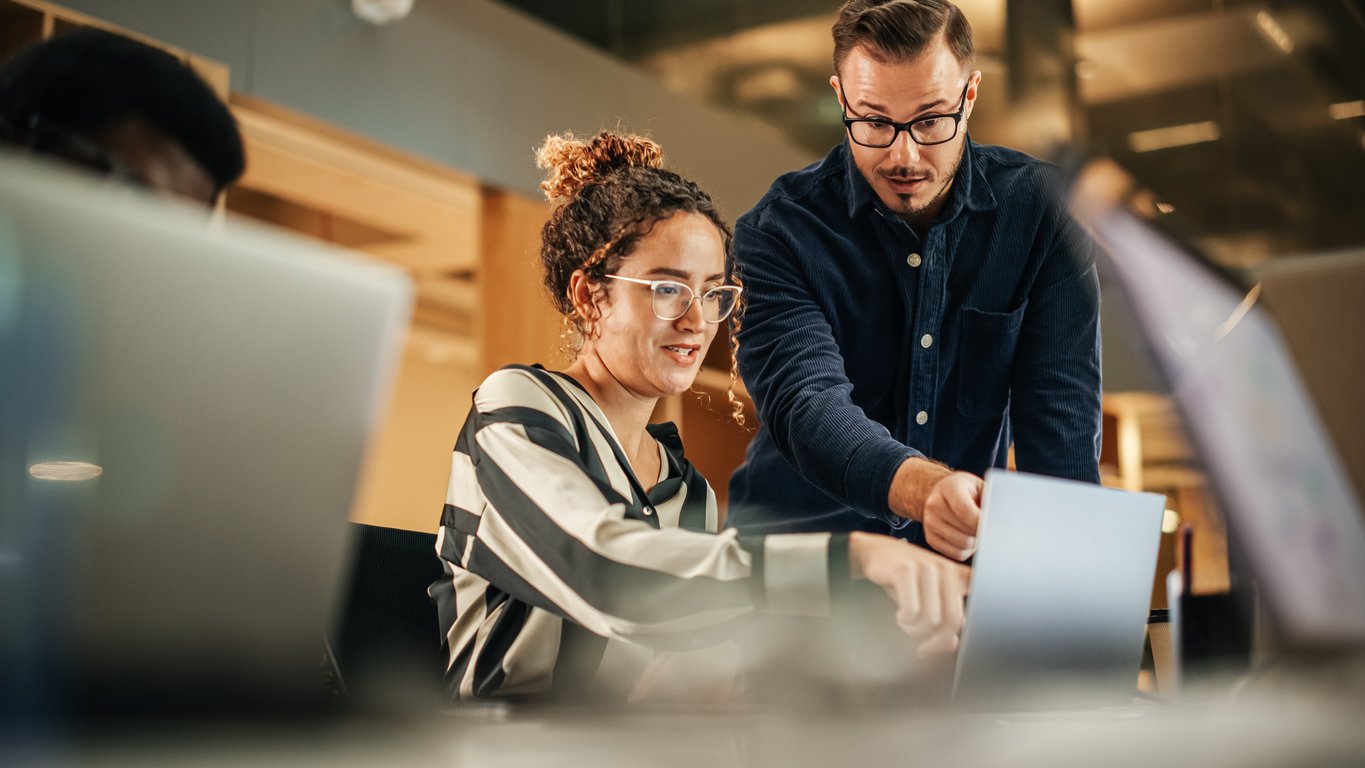 Managed IT services providers - Two IT professionals discussing in an office setup.