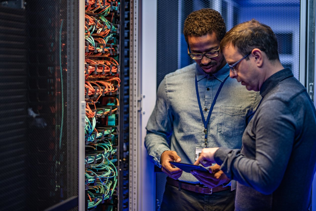 Concept of switch MSPs and get better server support from your provider illustrated by two guys in a server room working on servers