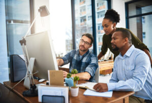 Switching MSPs - MSPs in an office using a computer while discussing services.